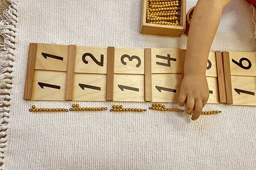 Close-up of hands working with Montessori counting materials